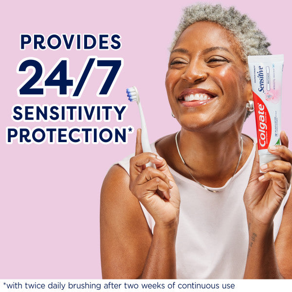 A woman smiling holding a toothbrush and a tube of Colgate Sensitive Maximum Strength Whitening Toothpaste. In text: Provides 24/7 sensitivity protection*. *With twice daily brushing after two weeks of continuous use.