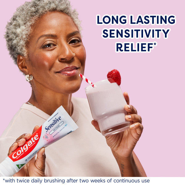 A woman holding a strawberry smoothie and a tube of Colgate Sensitive Maximum Strength Whitening Toothpaste. In text: Long lasting sensitivity relief*. *With twice daily brushing after two weeks of continuous use.