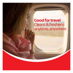 A woman looking out the window of a plane while using a Colgate Max Fresh Wisp Disposable Mini Travel Toothbrush. In text: Good for travel. Cleans & freshens anytime, anywhere.